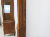 a tall wooden cabinet next to a tall wooden cabinet