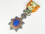 une image représentant une médaille ornée d'une pierre bleue au centre