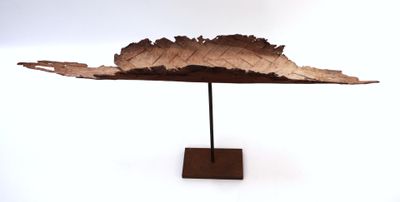 a sculpture of a leaf on a stand on a white surface