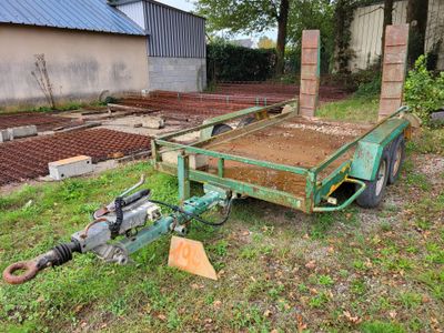 a green trailer that is sitting in the grass