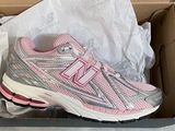 pink and silver new balance running shoes in a box
