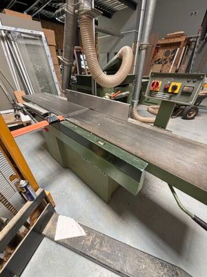 a machine that is cutting a piece of wood in a factory