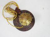 brass plate with a rope and a wooden handle on a white surface