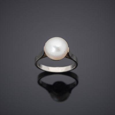 a white pearl ring on a black surface
