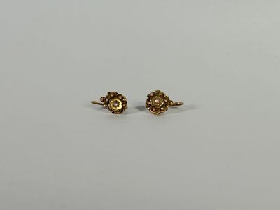 une paire de boucles d'oreilles en or sur fond blanc