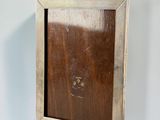 an old wooden picture frame hanging on a white wall