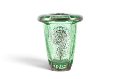 un vase en verre vert orné d'un motif floral