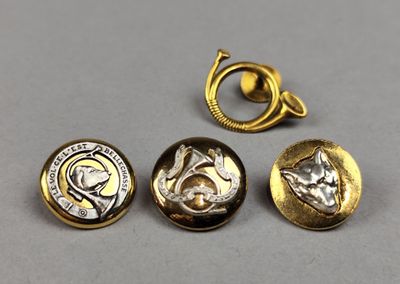 a close up of three gold and silver buttons on a gray surface