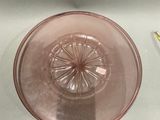 a pink glass bowl sitting on a table next to a toothbrush