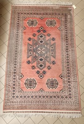 un tapis orange et noir posé sur un sol carrelé blanc