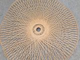 a close up of a circular rattan on a concrete surface