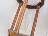 a wooden stool with three wooden legs on a white sheet