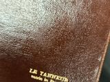 brown leather wallet with a gold logo on the front of it