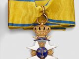 an image of a gold medal with a blue ribbon and a crown on it