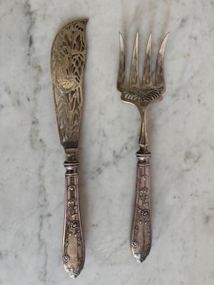 deux fourchettes et un couteau posés sur une table en marbre