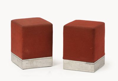 pair of red cube ottomans with silver bases on a white background