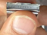a person holding a piece of metal with a ruler on it