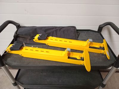 two yellow tools on a cart in a garage