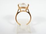 a close up of a gold ring with a white diamond on it