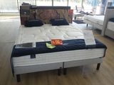 un lit qui se trouve au milieu d'une pièce remplie de meubles