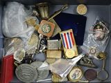 une boîte remplie d'objets divers, parmi lesquels des médailles et d'autres objets