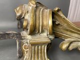 a gold sculpture of a man on a bench