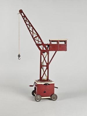 a red toy crane that is sitting on a cart