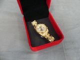 gold plated watch in a red box on a white cloth