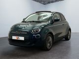 La petite voiture verte est garée dans une grande pièce.