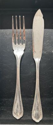 two forks and a knife sitting on a table