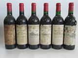 six bottles of wine are lined up in a row on a table