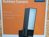 the box of a smart outdoor camera sits on a wooden surface