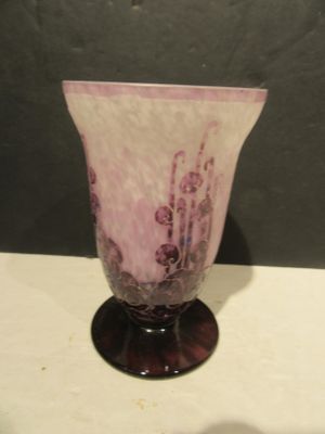 a purple vase sitting on a table with a black background