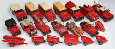 beaucoup de petits camions rouges en plastique sur une surface blanche