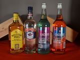 several bottles of alcohol are lined up on a red table