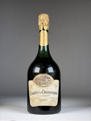 une bouteille de champagne posée sur une table, avec un verre de vin devant