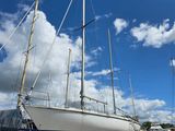 Plusieurs voiliers sont alignés sur la plage sous un ciel bleu