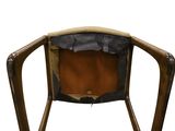 the back of a wooden chair with a leather seat and back rest