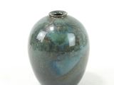 a blue and green vase sitting on a white surface