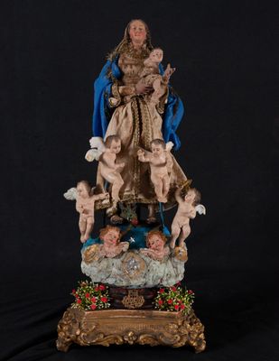 une statue de la Vierge entourée d'anges et de chérubins sur fond noir