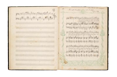 an open book with music notes on it on a white surface