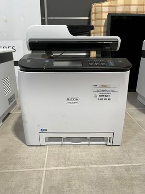 a printer that is sitting on the floor in front of a washing machine