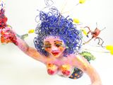 une sculpture représentant une femme aux cheveux bleus, ornée de fleurs dans les cheveux