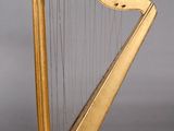an image of a golden harp sitting on top of a wooden stand