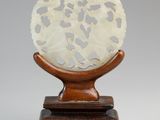 une photo d'une sculpture blanche et marron posée sur un socle en bois