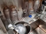 a metal bucket with a spoon in it in a kitchen