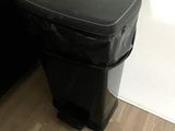 a black trash can sitting next to a black trash can