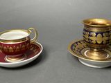 two cups and saucers are sitting side by side on a table