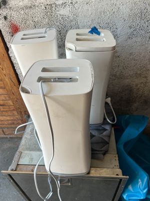 trois toilettes blanches posées sur une caisse en bois