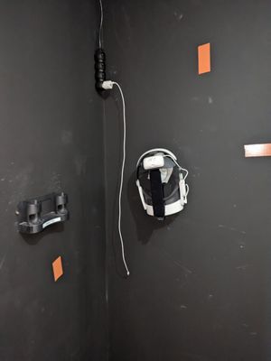 des toilettes dans un coin d'une salle de bains, avec un casque accroché au mur